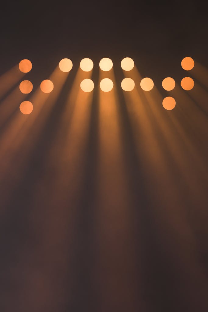 Abstract image of multiple spotlights casting bright rays in darkness.
